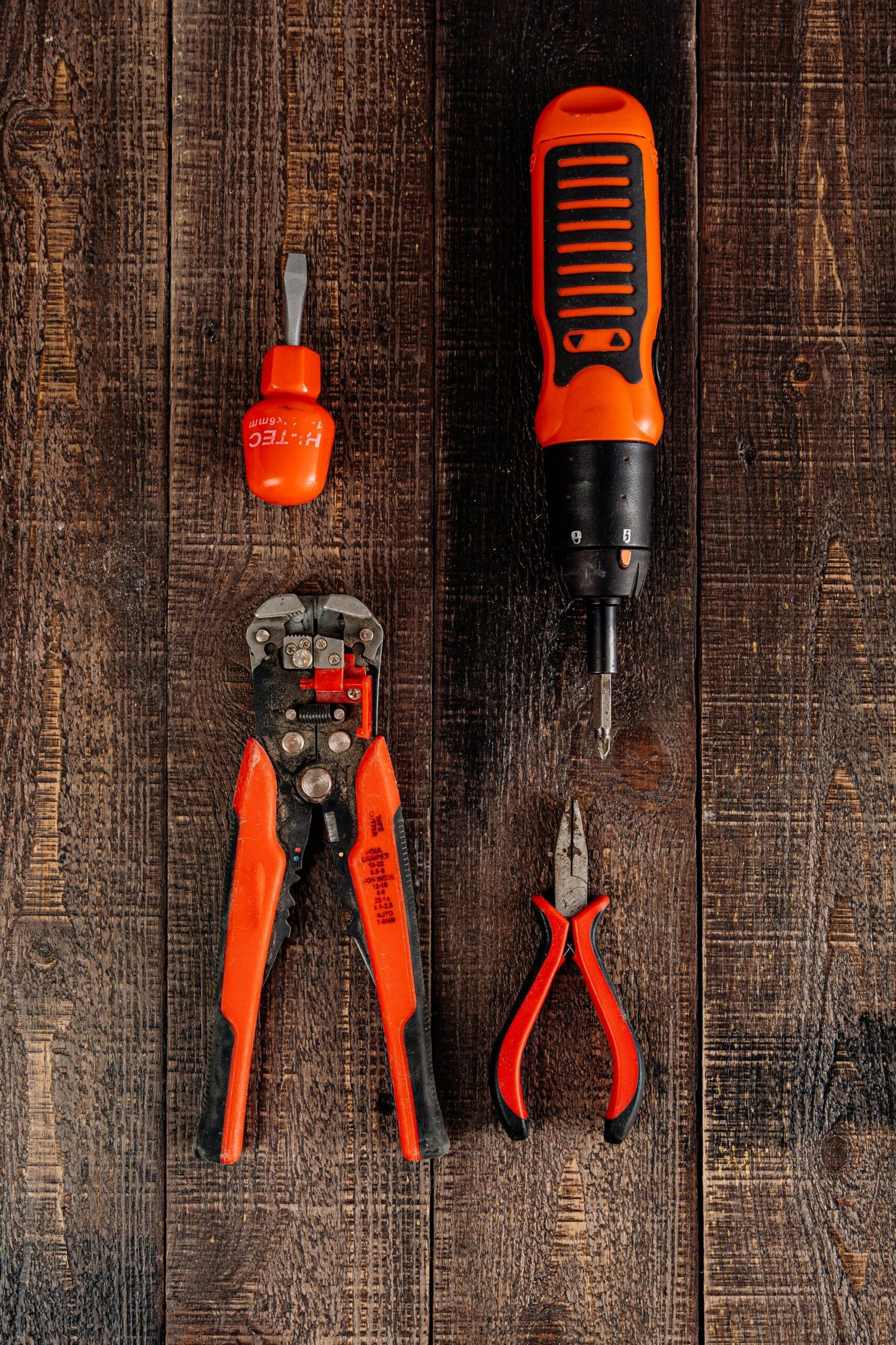 Flat lay view of various red tools on a wooden surface, perfect for DIY and workshop themes.