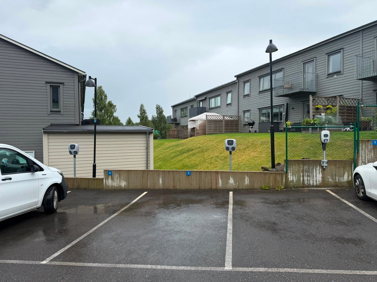 Laddboxar installerade vid numrerade parkeringsplatser i bostadsområde med flerfamiljshus